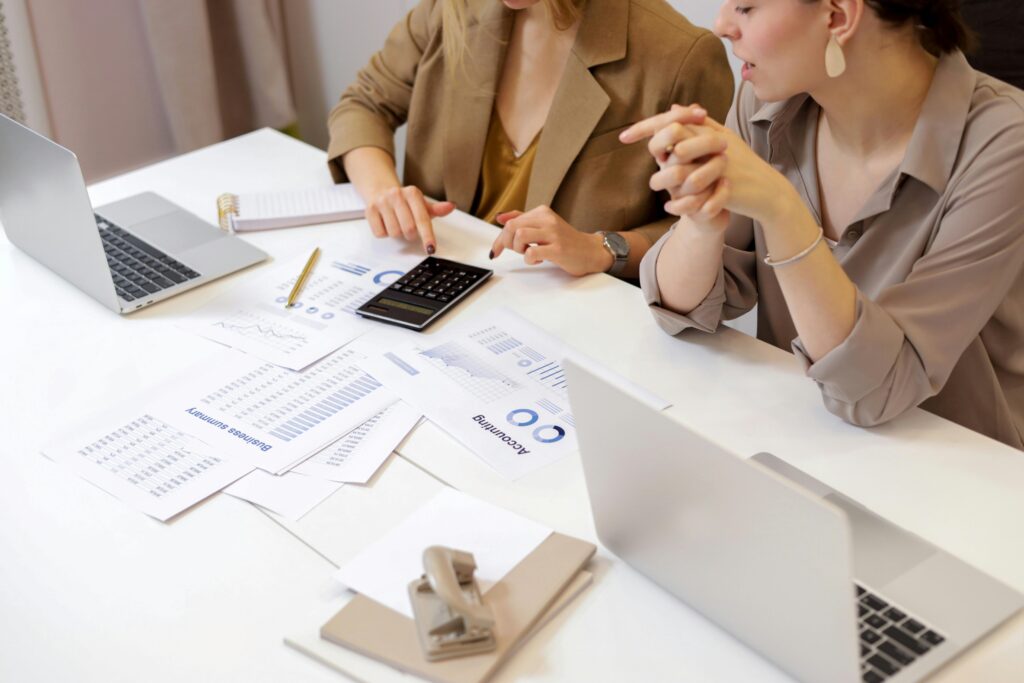 Two professionals reviewing financial reports and calculations at a desk, representing discussions and compliance related to superannuation accounting laws.